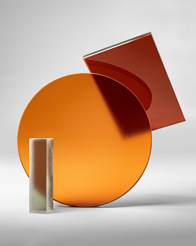 A rectangular marble 3form block stands in front of an orange oval and a red rectangle, all set against a neutral background.