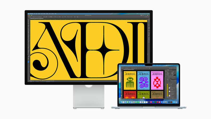 A desktop monitor and a laptop display colorful graphic designs, with the monitor showing large stylized letters and the laptop displaying four colorful symbols.