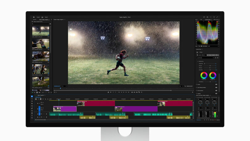 A computer monitor displays a video editing software interface, showing a scene of a person running in the rain on a sports field, with various editing tools and timelines visible.