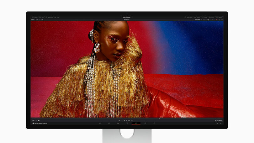 A computer monitor displays an image editing program showing a portrait of a person wearing gold fringe and pearl accessories against a red and blue background.