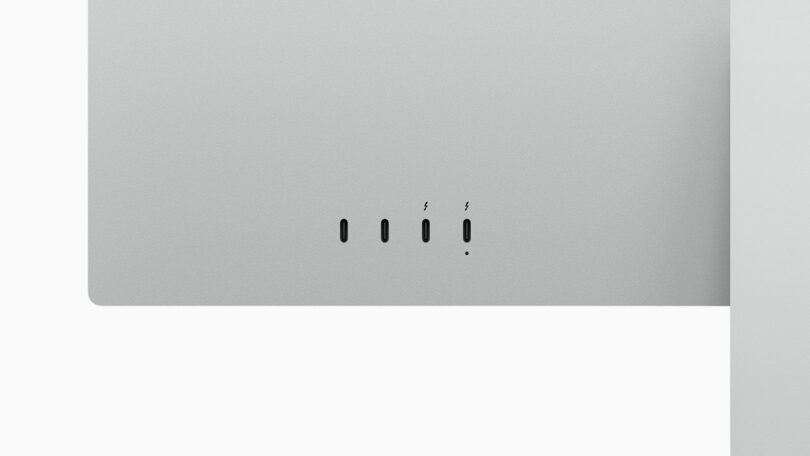 Close-up of a silver computer showing four ports on the back, including two Thunderbolt ports, one USB-C port, and one headphone jack.