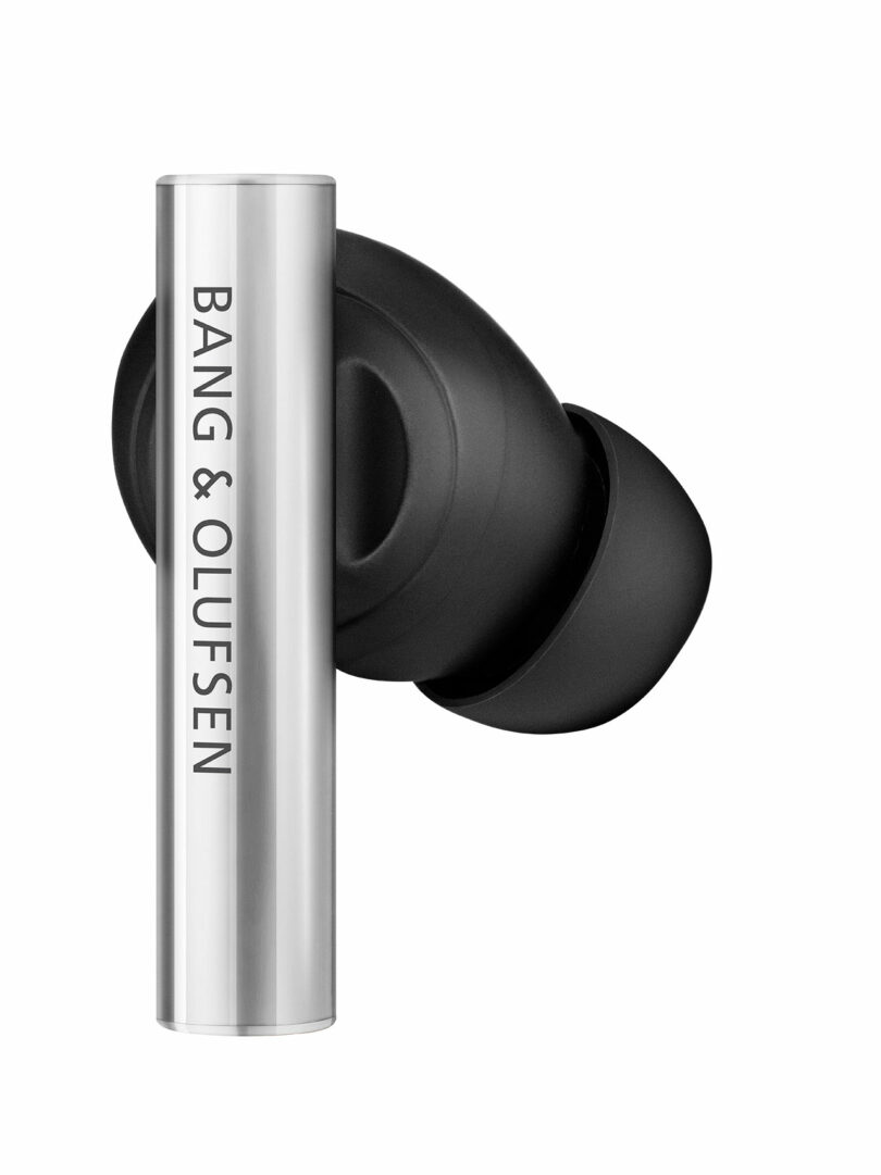 A single black and silver Bang & Olufsen wireless earbud with the brand name printed vertically on the metallic side.