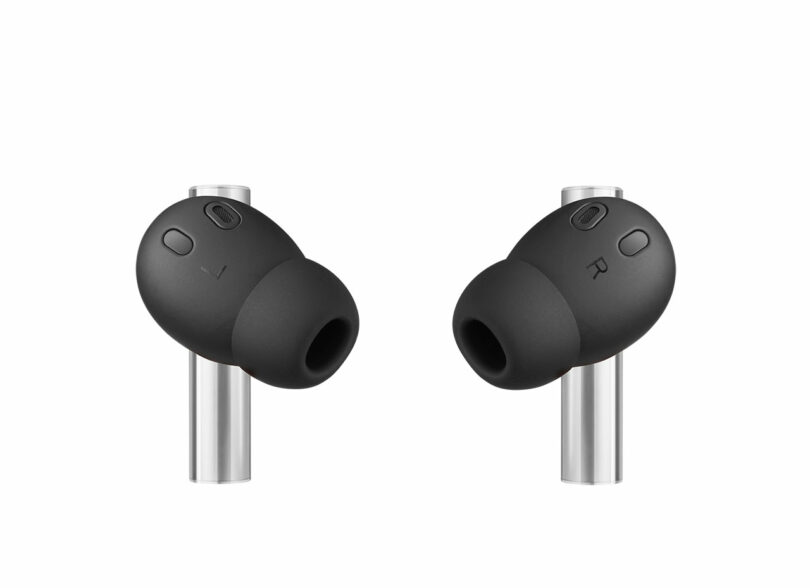 A pair of black wireless earbuds with silver stems, marked L for left and R for right.