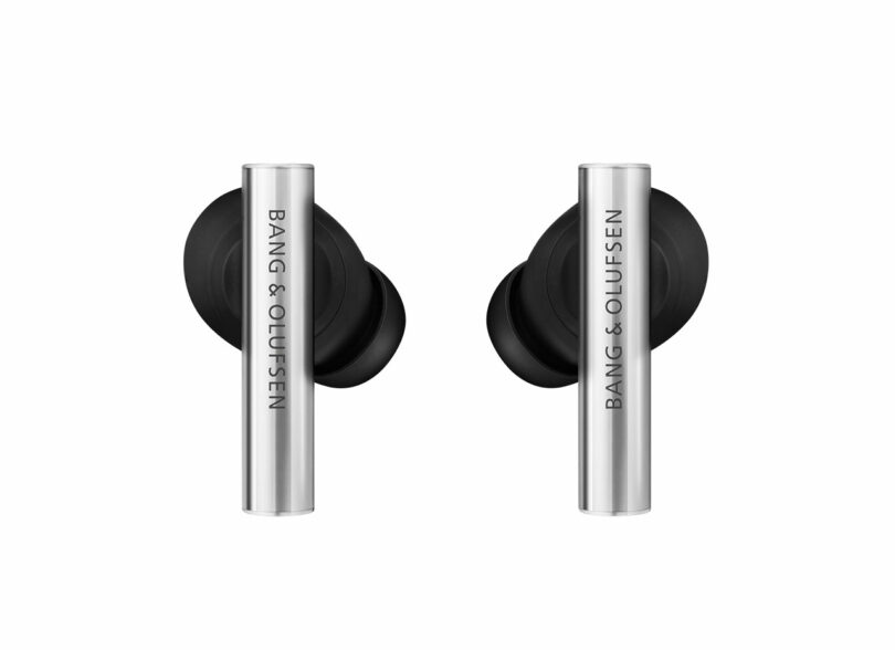 A pair of Bang & Olufsen wireless earbuds in black and silver, displayed side by side on a white background.
