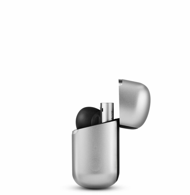A pair of wireless earbuds in a silver charging case with the lid open, showing one earbud partially exposed.