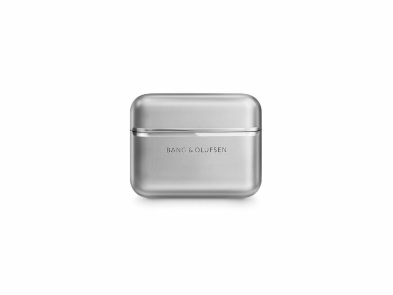A silver Bang & Olufsen wireless earbud charging case is centered on a white background.
