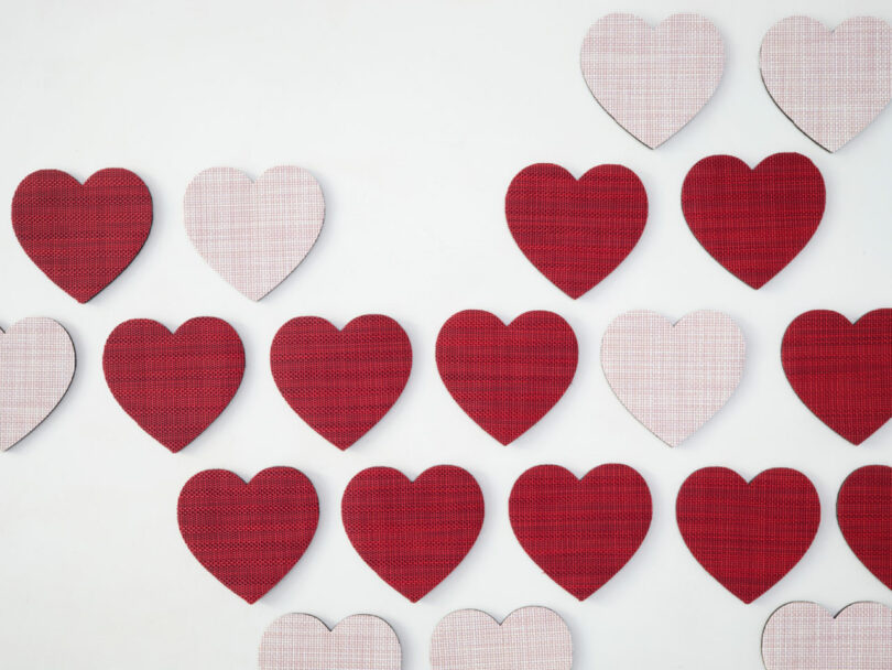 Rows of red and light pink heart shapes arranged in a pattern on a white background—perfect for Valentine's Day Gifts.