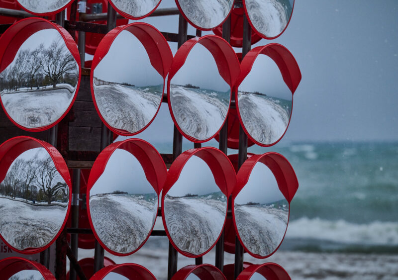 Chimera, mirror art installation on winter beach in snowstorm