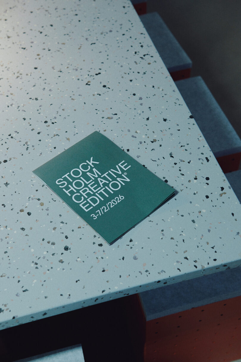 A green flyer reading "Stockholm Creative Edition 3-7/12/2026" lies on a speckled, light blue surface with stacked steps visible, capturing the innovative spirit of Form Us With Love.