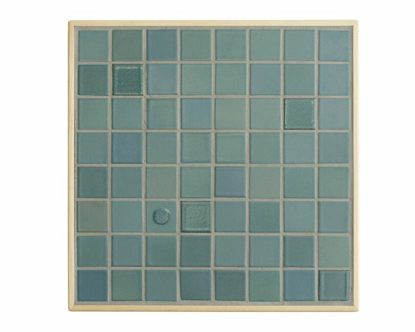 A square grid of blue-green tiles with subtle texture variations, framed by a light wood Artek border. Some tiles have different finishes or patterns.