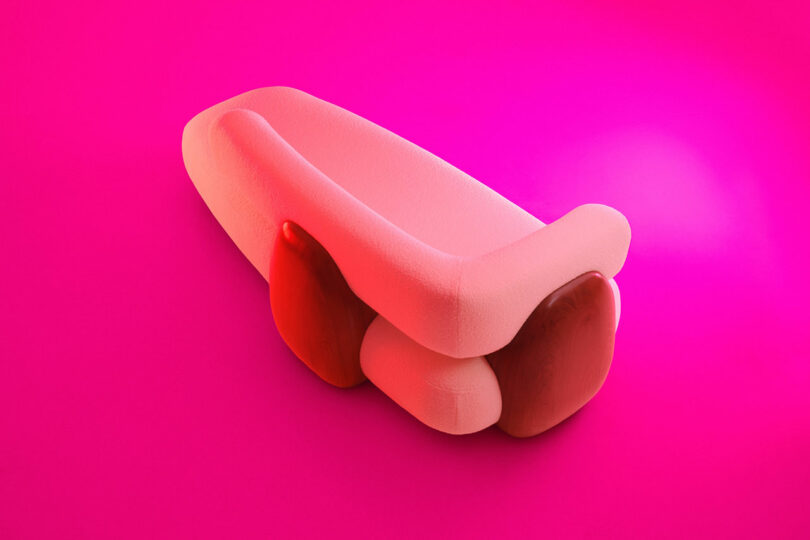 A soft, abstract pink and red sculptural object rests on a bright pink background, reminiscent of the refined aesthetic found in Holly Hunt designs.