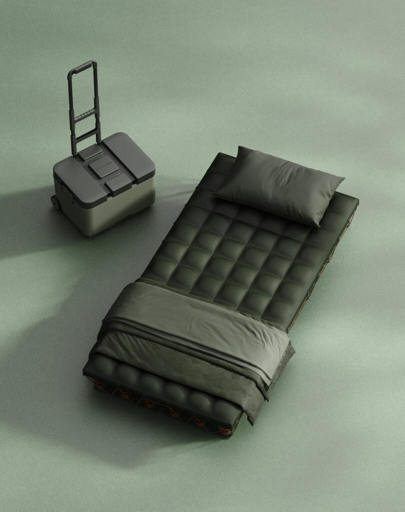 A portable bed with a pillow and blanket is set up next to a wheeled storage container on a smooth, green surface.