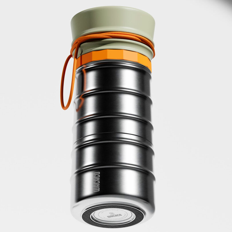 A metallic, ribbed insulated bottle with a beige cap, orange strap, and an orange accent near the top, displayed against a white background.