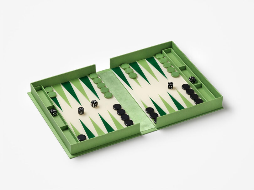 A green and white backgammon set with black and green playing pieces and dice arranged on the board.