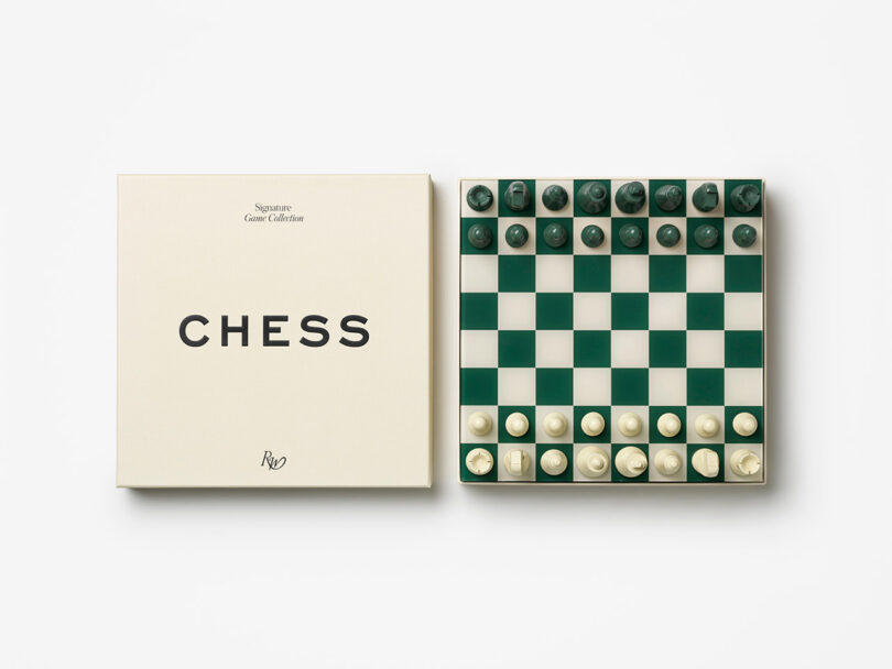 A closed chess box labeled "CHESS" sits next to a green and white chessboard with pieces set up for the start of a game, viewed from above.
