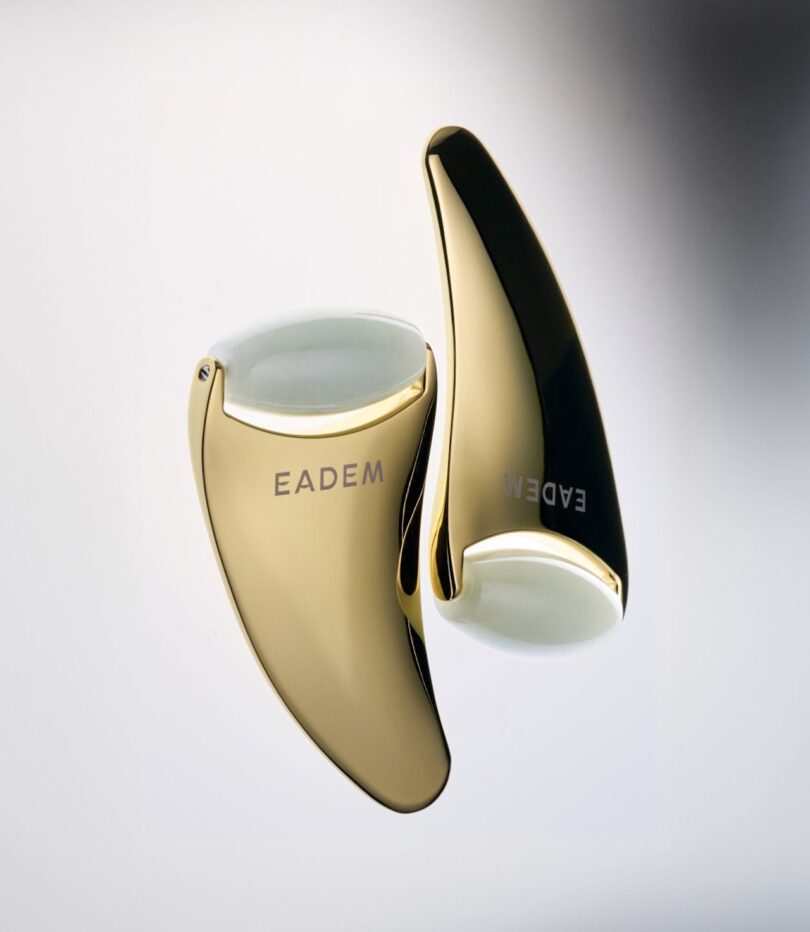 Eadem's The Chisel - a 2-in-1 gua sha/facial sculpting tool with a gold body and jade roller. There are two next to each other; the one on the left is upright and the one on the right is upside down.