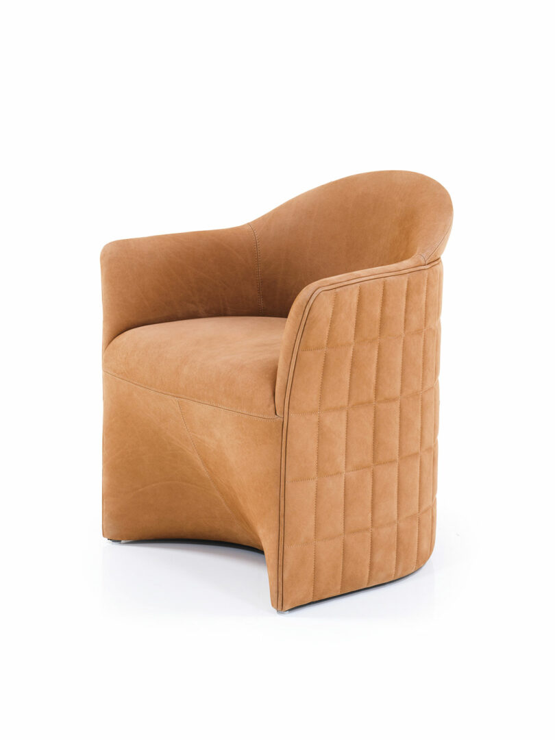 Tan leather Wittmann armchair with a curved backrest and quilted stitching on the exterior side panel, shown on a white background.