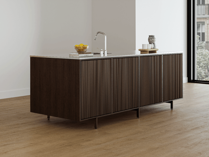 A modern Vipp kitchen island with a dark wood finish, marble countertop, sink with faucet, and items including a bowl of lemons and glass jars.